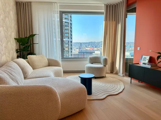 Svetlá obývačka apartmánu v projekte Skypark s veľkým oknom a výhľadom na Bratislavu